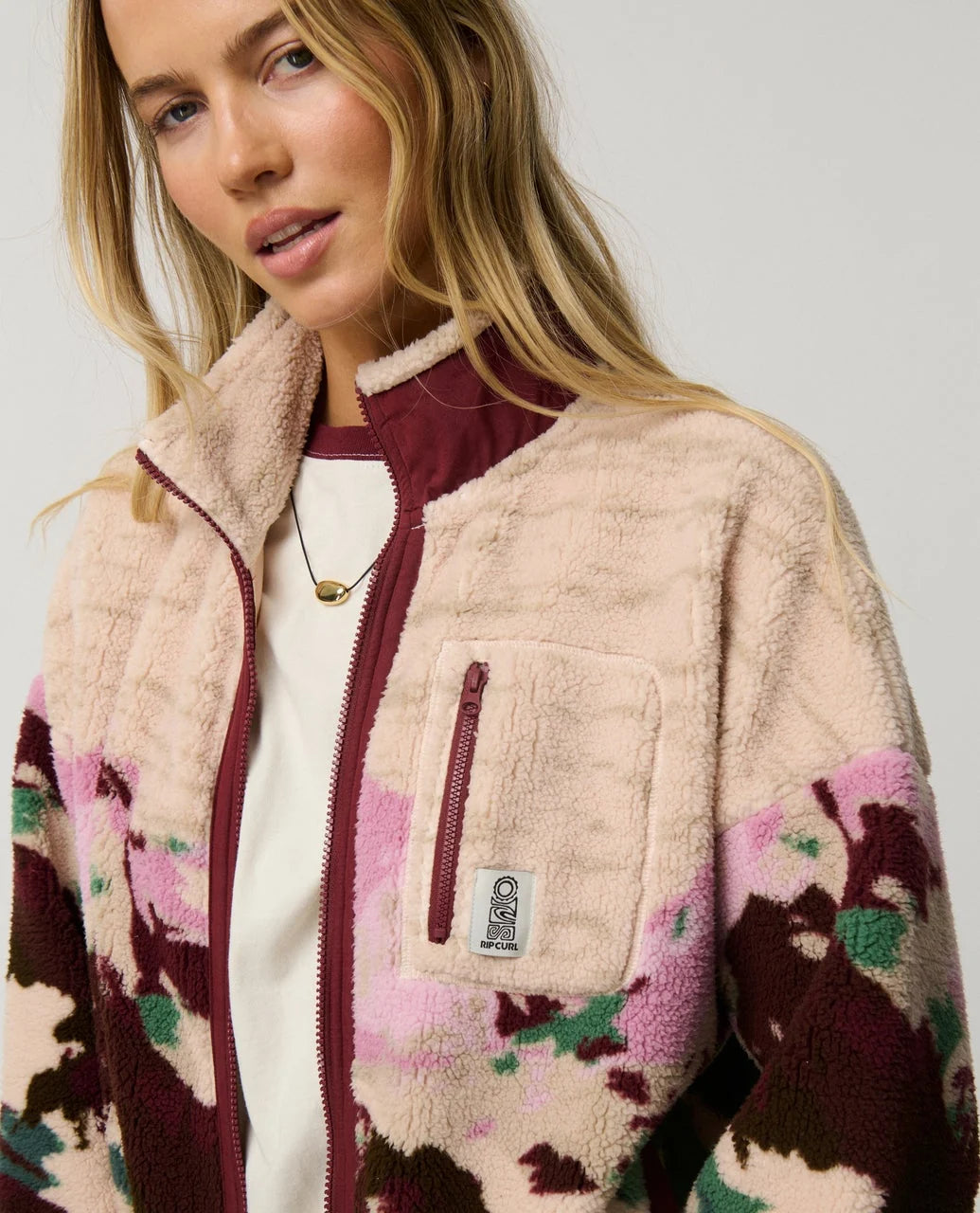 Polar fleece zip-through jacket close-up of chest pocket, full zip and plum camo print