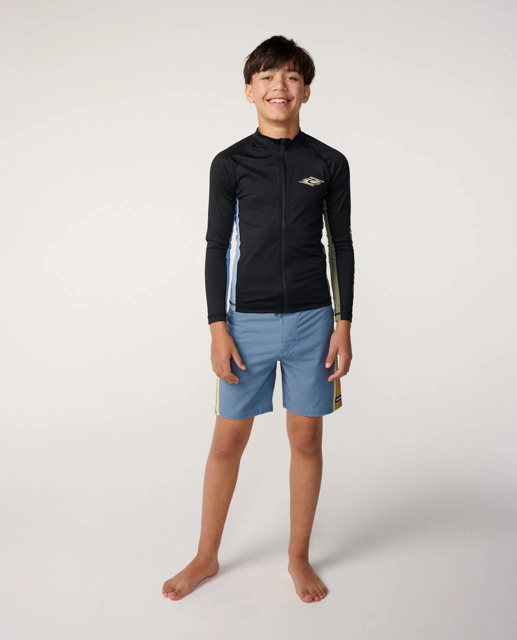 Junior long-sleeve black zip rash guard with chest logo, worn over swim shorts