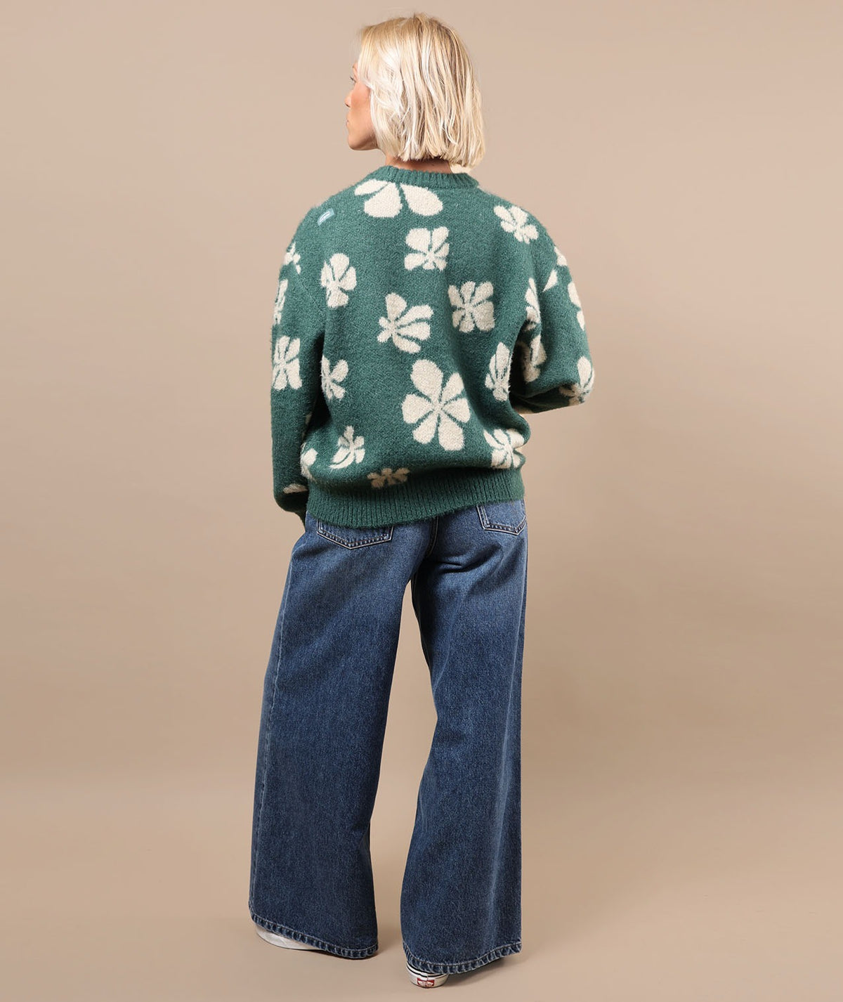 Green crewneck sweater with white floral pattern, long sleeves and ribbed hem