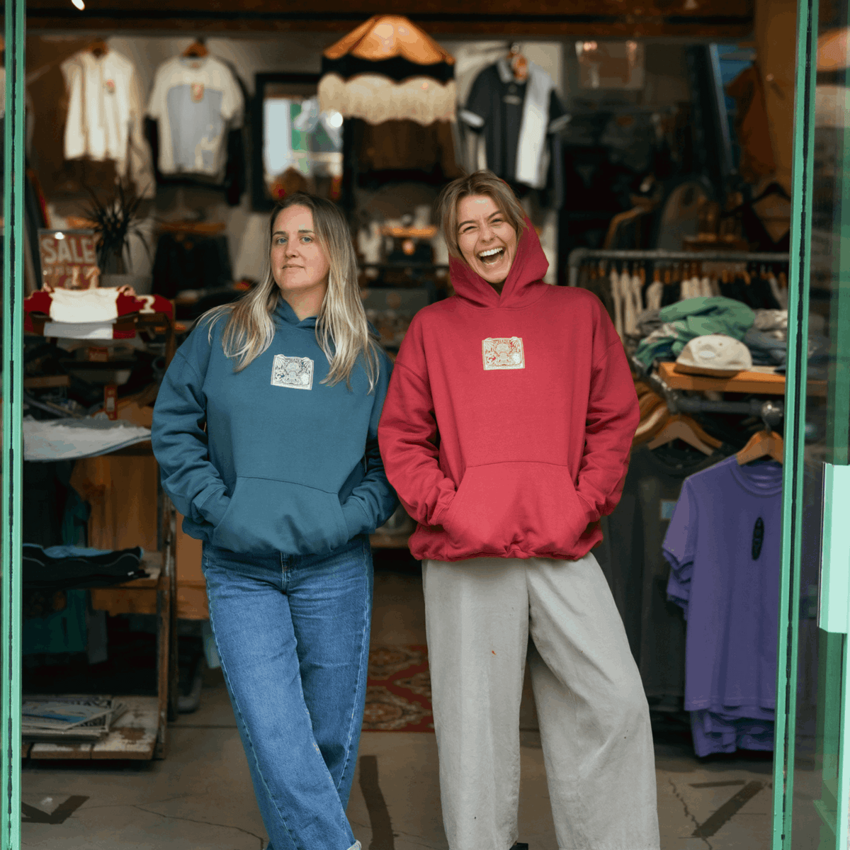 Teal hooded sweatshirt with front square graphic, worn with jeans
