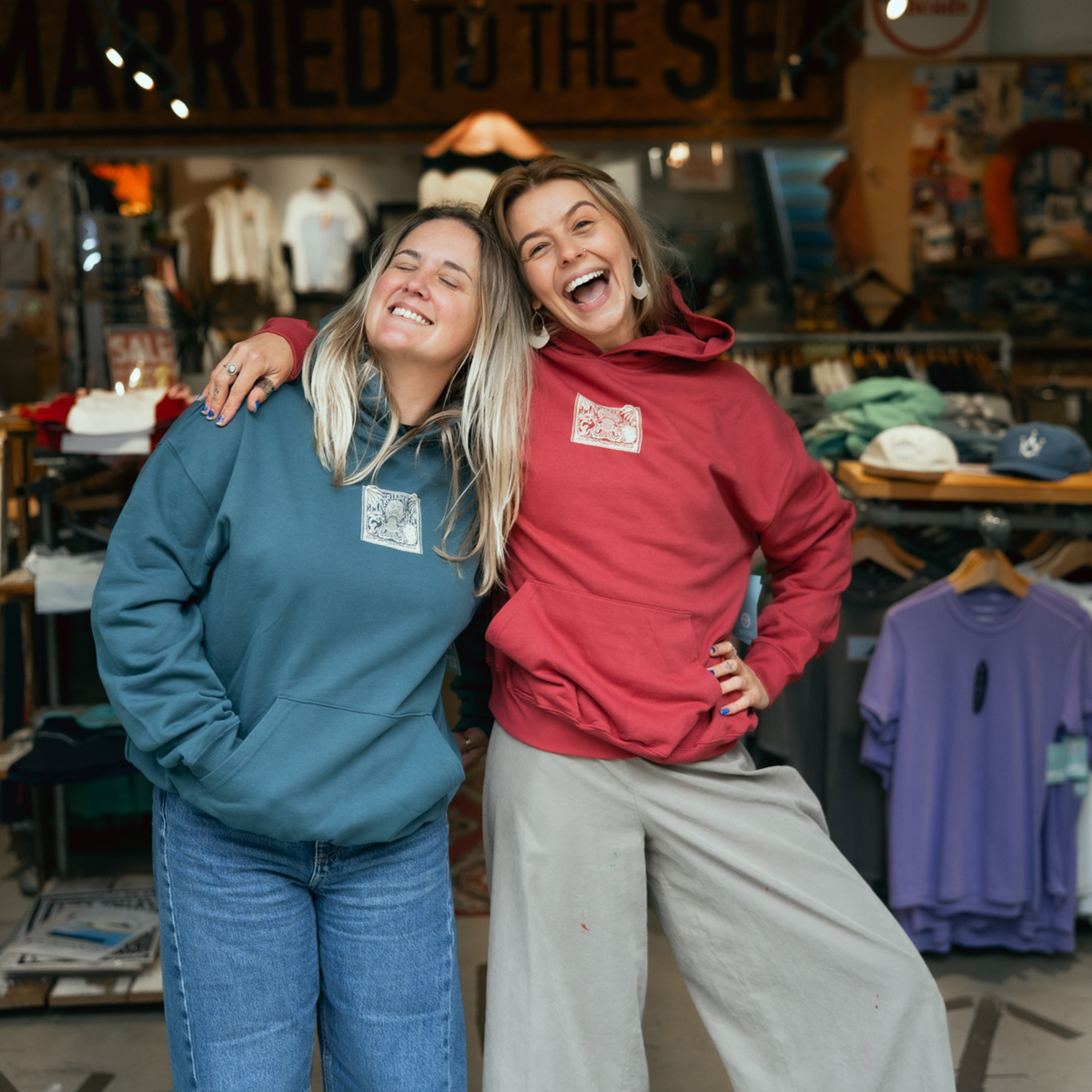 Red earth pullover hoodie with small chest emblem and drawstring hood