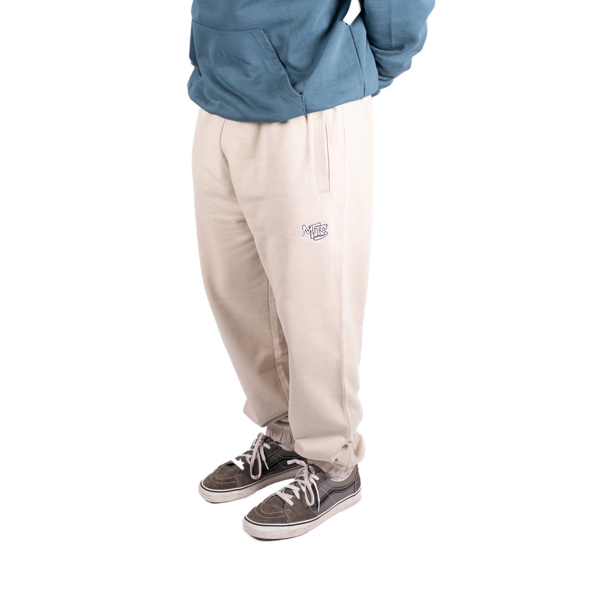 Desert Dust joggers with a small leg logo and tapered cuffs, shown from the front.